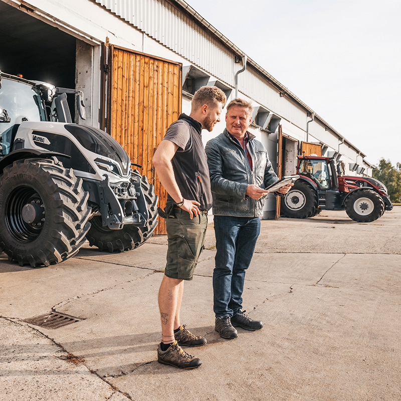 Valtra Q-Serie mit Kunde und Händler vor der Maschinenhalle