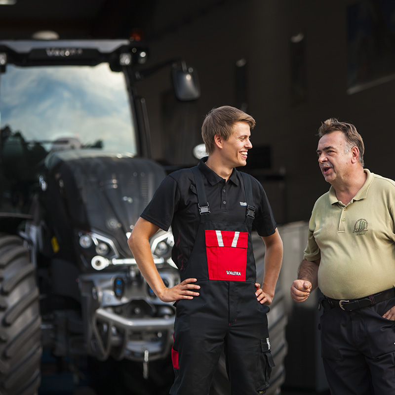 Valtra Servicetechniker und Kunde vor Valtra Traktor