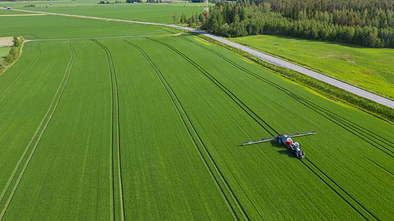 Valtra Traktor mit gezogener Pflanzenschutzspritze